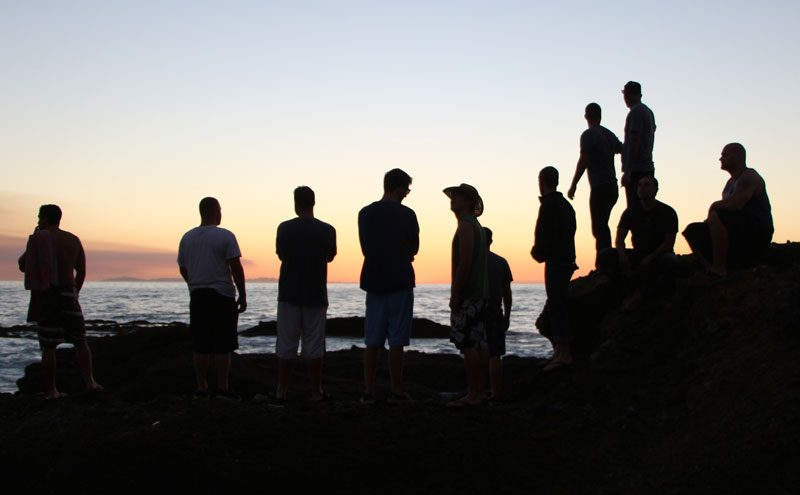 Men watching sunrise at the beach