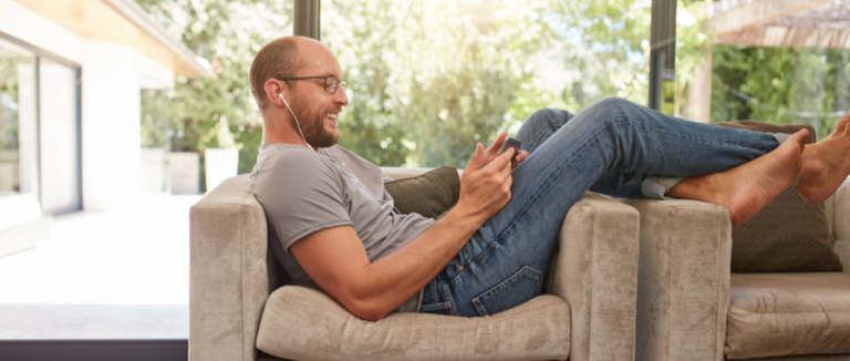 man hanging out on the couch laughing