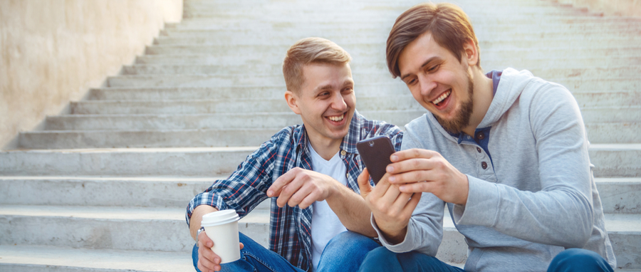 two men laughing at ones phone